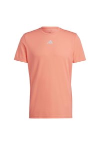 Camisa deportiva de hombre de manga corta en color coral claro, hecha de tela lisa. Cuenta con un logo blanco en el pecho y un diseño de cuello redondo.