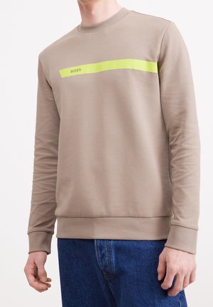 Beige sweatshirt met een ronde hals, voorzien van een horizontale neongele streep op de borst en geribbelde manchetten. Zachte stof en een ontspannen pasvorm.