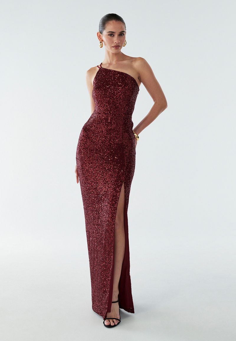 burgundy sequined gown with a single shoulder strap, side slit, fitted design, and smooth texture; paired with strappy black heels.