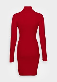 Robe rouge côtelée à col roulé avec manches longues, silhouette ajustée et texture lisse, dotée d'un col haut et d'une coupe à hauteur du genou.