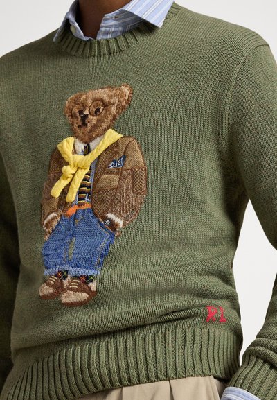 Πλεκτό πράσινο πουλόβερ με λεπτομερή κεντημένη αρκούδα που φορά καφέ σακάκι, κίτρινο κασκόλ και μπλε τζιν; κόκκινο διακοσμητικό "RL", ριμπ τελείωμα.
