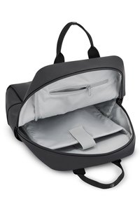 Mochila negra con un exterior suave. Presenta un interior gris, un bolsillo con cremallera y un compartimento acolchado asegurado con una correa.