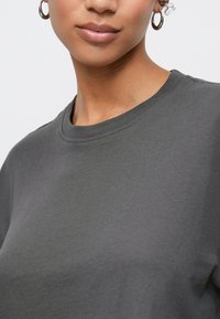 Gray cotton t-shirt featuring a crew neckline and short sleeves, with smooth texture and minimal stitching detail.