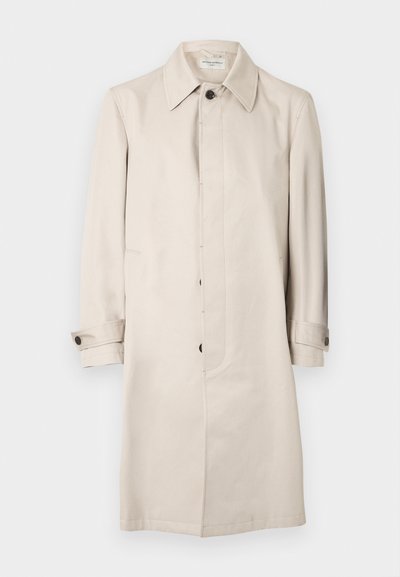 Μπεζ παλτό τύπου τρεντς με κούμπωμα μπροστά, μακριά μανίκια και πλαϊνές τσέπες. Διαθέτει γιακά στο λαιμό και γυριστά μανίκια. Ομαλή υφή.