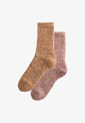 Two pairs of socks in a woven texture. One pair is light brown, the other is light pink with flecks of brown, showcasing a cozy design.