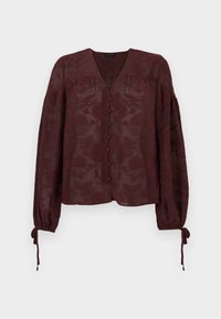 Blouse bordeaux transparente à manches longues avec motif floral en relief, boutons recouverts de tissu à l'avant, col en V et poignets noués.