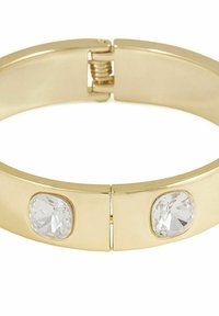 Guldfärgad bangle-armband med två klara, ovalformade stenar på vardera sidan, med en slät, polerad yta och en spännardesign.