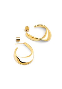Pendientes de aro en tono dorado con un diseño pulido y curvado. Presentan una textura suave y un cierre cilíndrico para un uso seguro.