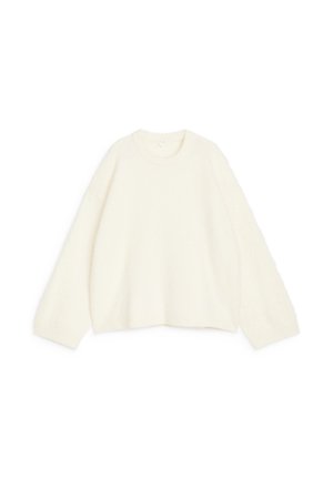 Chunky knit sweater in off-white, featuring a round neckline, long sleeves, and a relaxed fit, with soft, textured fabric.