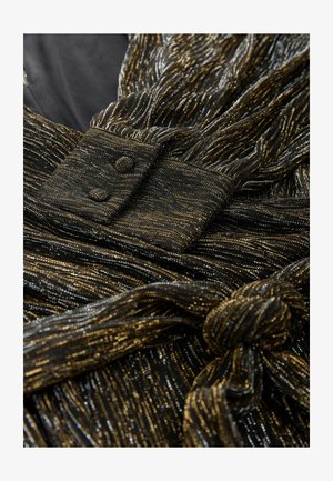 Material pentru rochie neagră și aurie cu fire metalice, având o suprafață texturată, o curea legată și un accent cu două nasturi.