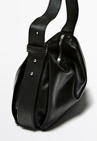 Borsa a tracolla in pelle nera con un design arrotondato, chiusura con zip superiore e manico largo. Presenta accessori in argento e una superficie liscia e testurizzata.