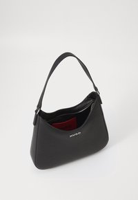 Černá kožená kabelka s oblým tvarem, krátkým uchem a zipovým uzávěrem. Obsahuje stříbrný detail loga a červenou vnitřní podšívku.