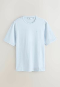 T-shirt bleu clair à manches courtes et col rond avec un petit logo discret sur le côté gauche de la poitrine, présenté sur un fond neutre.