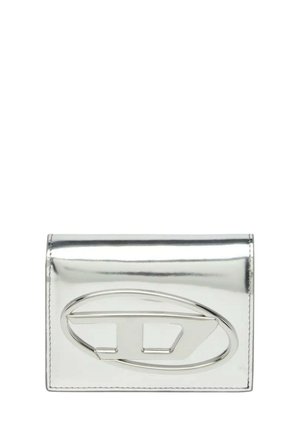 Piccolo portafoglio rettangolare metallico argento con un logo metallico rettangolare arrotondato al centro davanti.