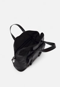 Sac à main en cuir noir texturé avec deux anses et une fermeture éclair ouverte, révélant un intérieur spacieux avec une poche zippée à l'intérieur.