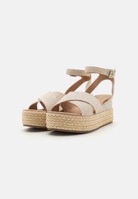 Beige kilklackssandaler med tvärgående remdesign, textilöverdel, justerbar ankelrem och vävd juteplattformssula.