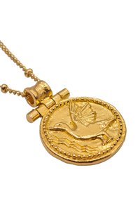 Collana con pendente dorato caratterizzata da un design a moneta testurizzata con un uccello in volo, bordi intricati e un bail cilindrico.