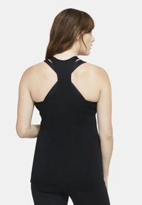 Top sportivo nero senza maniche con design a schiena scoperta e molteplici spalline. Tessuto morbido e silhouette aderente.