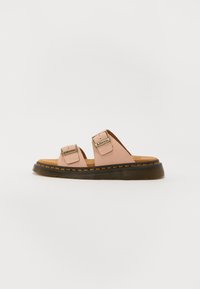 Sandales en cuir rose clair avec deux straps ajustables, semelle en caoutchouc noir, et piqûres jaunes contrastantes. Design plat et semelle intérieure texturée.