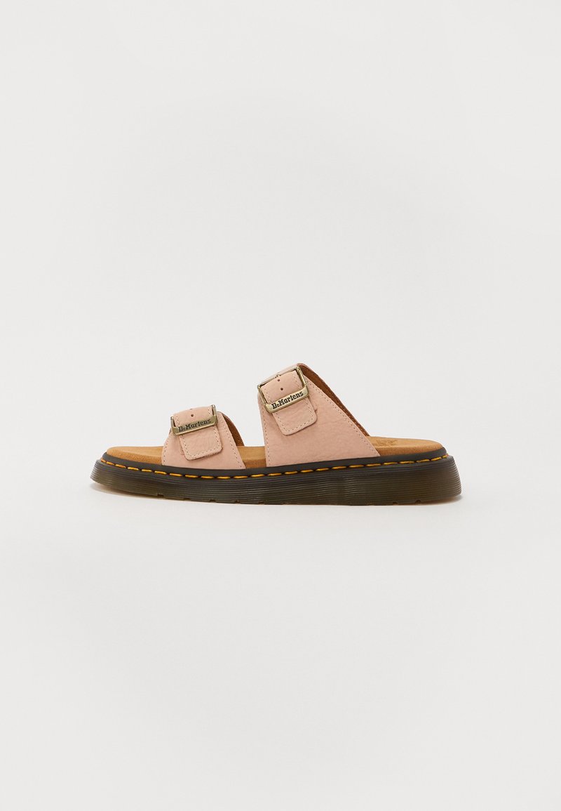 Sandales en cuir rose clair avec deux straps ajustables, semelle en caoutchouc noir, et piqûres jaunes contrastantes. Design plat et semelle intérieure texturée.