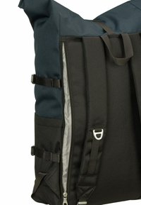 Zaino con ruote in tessuto nero testurizzato e blu scuro. Presenta cerniere, spallacci regolabili e un compartimento interno di colore chiaro.