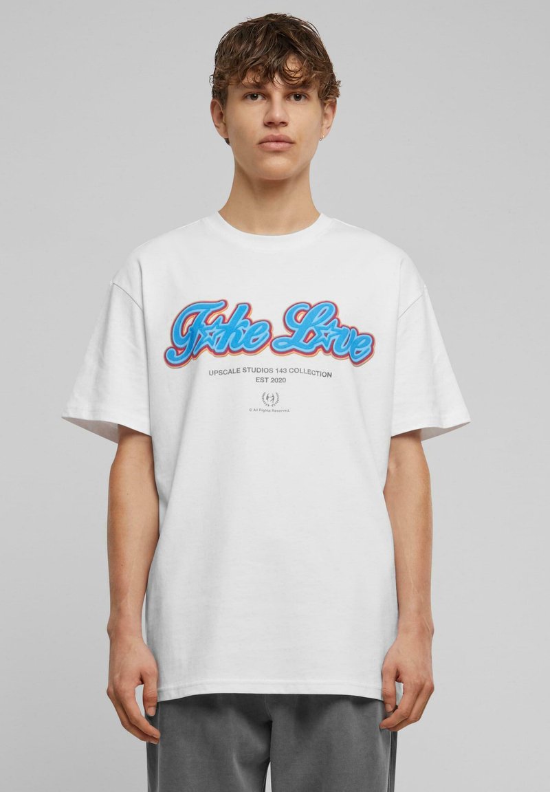 Hvid bomulds t-shirt med et farverigt "Take Love" grafik i blåt og rødt, med en afslappet pasform og korte ærmer.