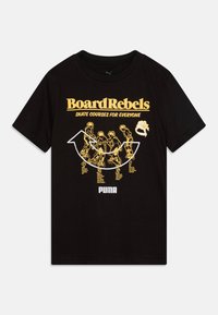 Černé bavlněné tričko s žlutou a bílou grafikou. Design zahrnuje text "BoardRebels" a ilustrace skejťáků s pokyny pro skateboarding.