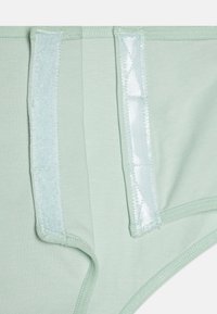Lichtgroen stoffen ondergoed met een gladde textuur, elastische tailleband en gaasaccenten aan de zijkanten voor ademend vermogen.