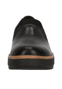 Chaussure en cuir noir avec un bout arrondi, dotée d'un design à enfiler. La semelle a une accentuation beige avec un fond en caoutchouc noir texturé.