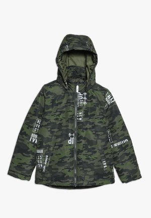 Kamuflagejakke med lynlås foran, tekstureret stof og en hætte. Har hvide trykte tekstaccenter på mørkegrønne og sorte mønstre.