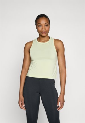 Lys grønn ermeløs tanktop med rund hals; mykt, elastisk stoff. Kombinert med tettsittende sorte leggings, noe som skaper et avslappet atletisk utseende.