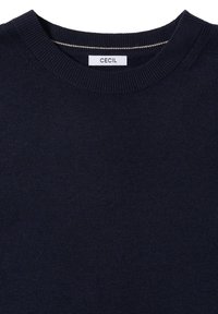Marineblauer Pullover mit Rundhalsausschnitt, gerippten Bündchen und Saum. Weicher, strukturiert Stoff mit einem Etikett, das "CECIL" am Ausschnitt trägt.