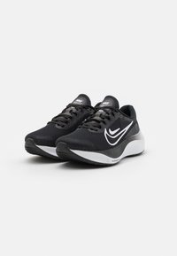 Zapatillas deportivas negras con parte superior de malla texturizada, logo de Nike en blanco y suela acolchada que presenta una ligera curvatura en el talón.