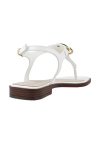 Sandalo in pelle bianca con suola piatta in legno, sottili cinturini e un accento in metallo dorato sul tallone. Progettato con uno stile minimalista.