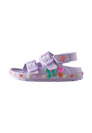 Purple children's sandal with two adjustable buckles, decorated with colorful butterfly, flower, and heart-shaped charms along the sole and strap.
