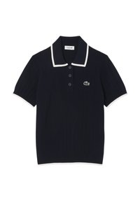 Polo navy en tissu côtelé, avec un col blanc et des bordures de manches blanches, comprenant trois boutons et un logo crocodile vert sur la poitrine.