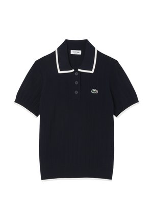 Navy polo shirt with ribbed texture, white collar and sleeve trims, featuring three buttons and a green crocodile logo on the chest.
