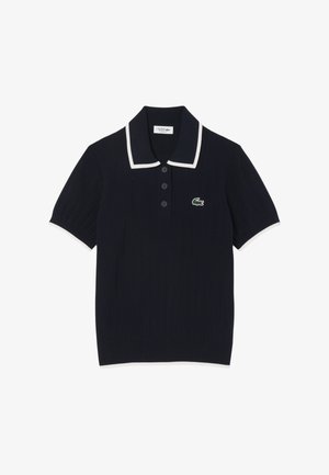 Marineblaues Poloshirt mit gerippter Textur, weißem Kragen und Ärmelabschlüssen, ausgestattet mit drei Knöpfen und einem grünen Krokodil-Logo auf der Brust.