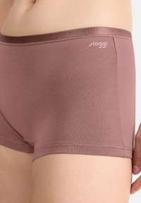 Ruskeat Sloggin bokserityyppiset alusvaatteet, joissa on pehmeä ja sileä pinta, leveä kuminauhahaarukka ja hillitty logodetalji.