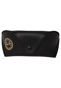 Étui à lunettes en cuir noir avec bords arrondis, surface texturée et fermeture à bouton. Présente un détail de logo doré.