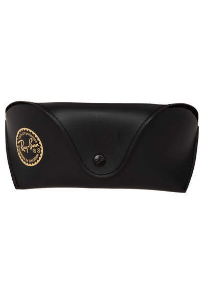 Étui à lunettes en cuir noir avec bords arrondis, surface texturée et fermeture à bouton. Présente un détail de logo doré.