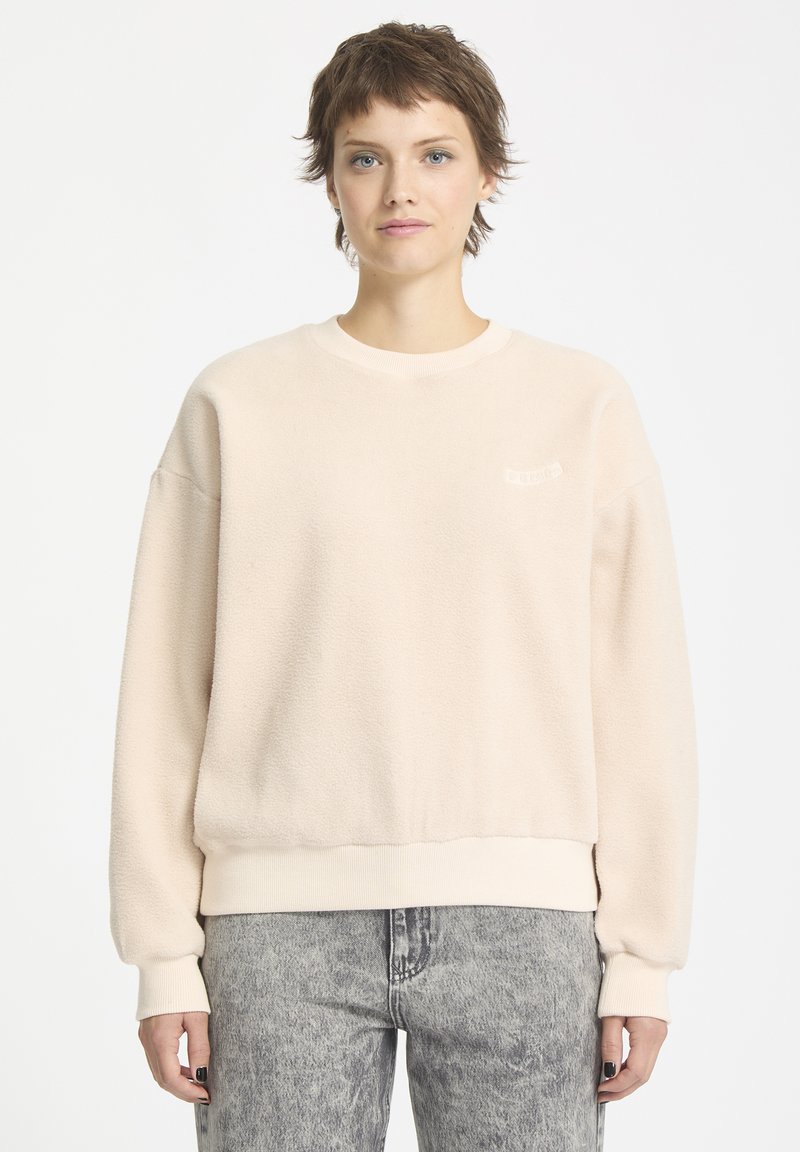 Helles beiges Fleece-Sweatshirt mit Rundhalsausschnitt und gerippten Bündchen, ausgestattet mit einem kleinen Logo auf der Brust und einem lässigen Schnitt.
