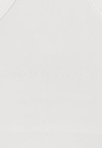 Vit sport-bh med ribbad textur och präglad "ENDURANCE"-logotyp. Har en enkel, stödjande design utan ytterligare detaljer.