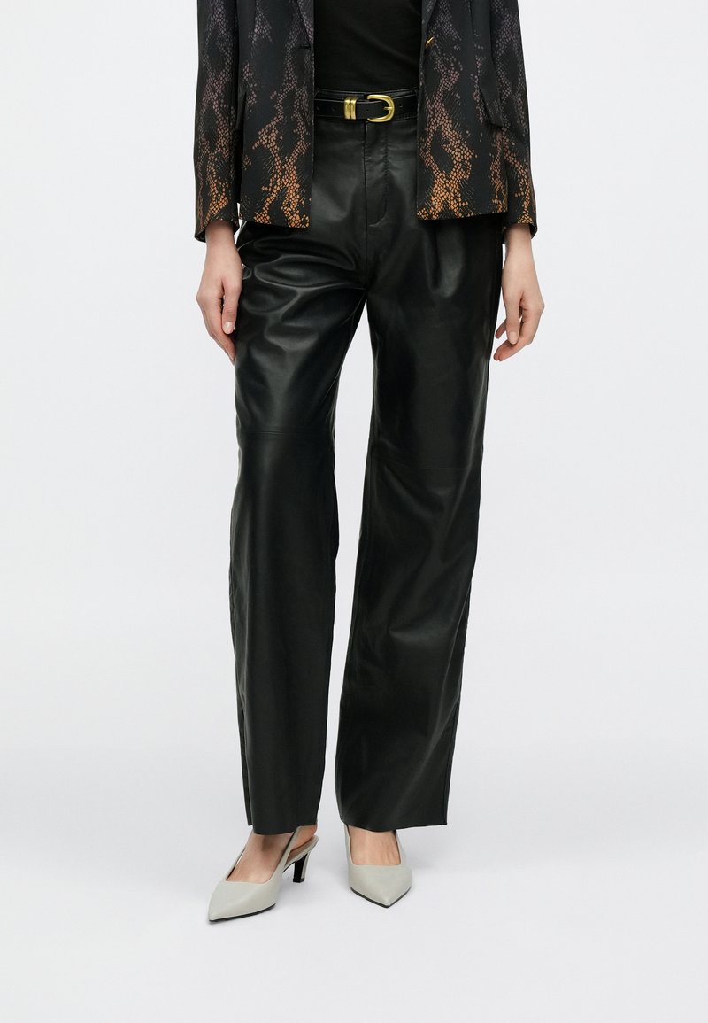 Μαύρο δερμάτινο παντελόνι με φαρδιά μπατζάκια και ψηλή μέση, με ομαλή υφή και μίνιμαλ σχεδιασμό. Διαθέτει χρυσή αγκράφα στη μέση ως διακοσμητικό στοιχείο.