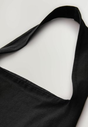 Sac en toile noir avec une large sangle plate et une texture lisse ; présente un design simple et une surface non ornée.