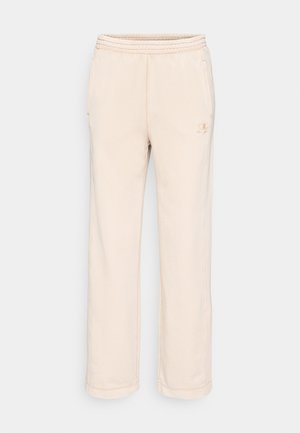 Beige Sweatpants aus weichem Material, mit elastischem Bund, zwei seitlichen Taschen und einem kleinen Logo am linken Bein.