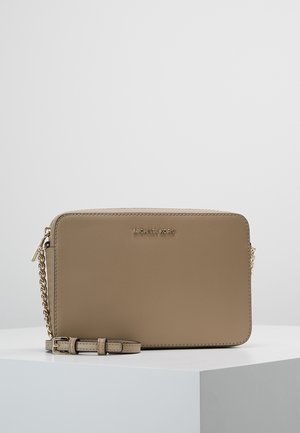 Bolso bandolera rectangular beige de Michael Kors con cadena dorada como correa y cierre de cremallera, exhibido sobre una superficie blanca.