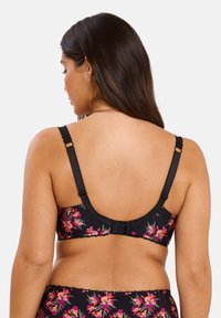 Zwarte bloemenbh met levendige roze bloemen, verstelbare banden met gegolfde randen en een haak-en-oog sluiting op de rug. Geverfde stof.