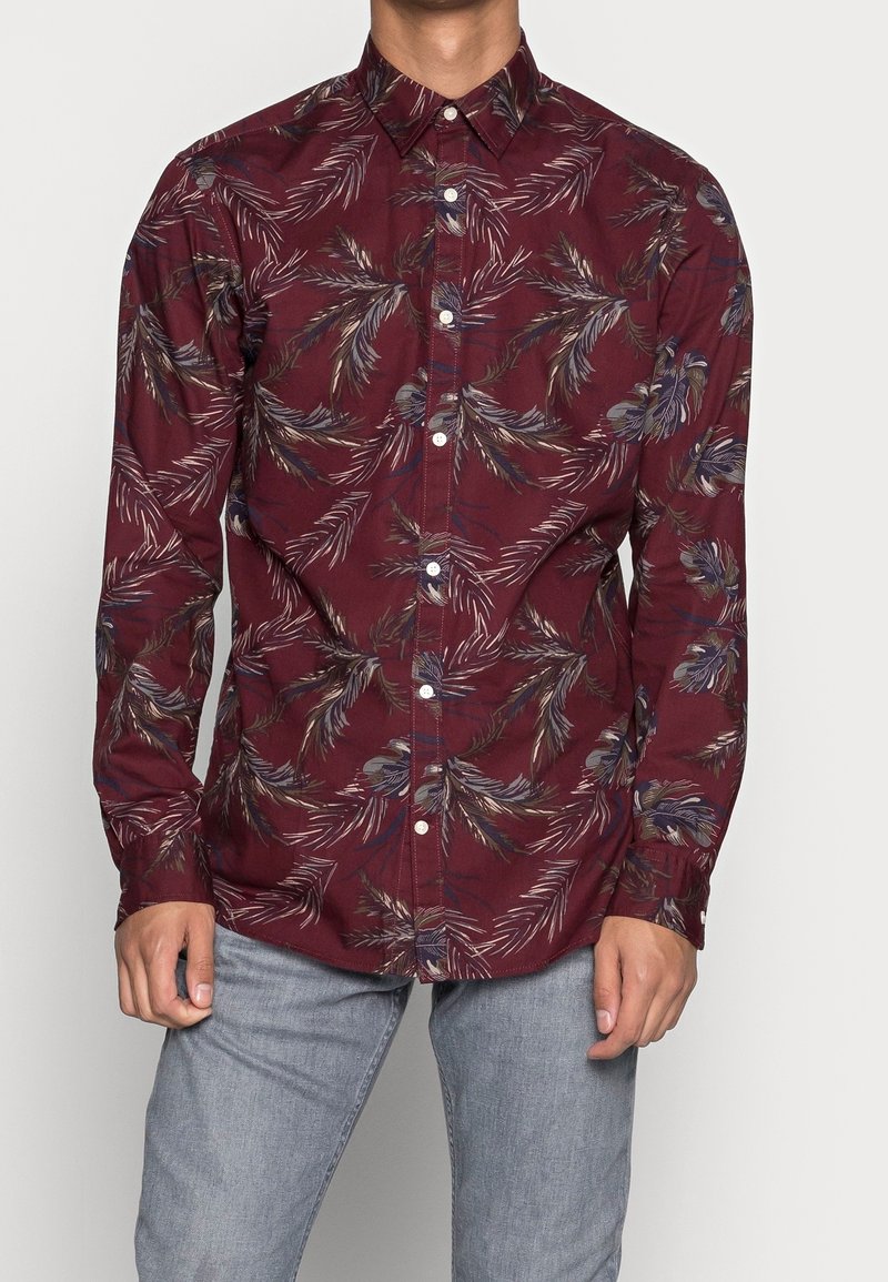 Bordowa koszula z długim rękawem, ozdobiona wzorem liści palmy w kolorze niebieskim i kremowym. Klasyczny kołnierzyk, zapinana na guziki z przodu, o gładkiej teksturze tkaniny.