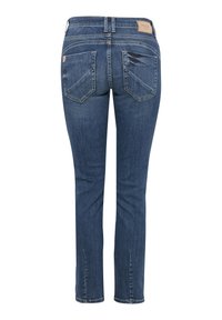 Jeans de mezclilla azul de corte slim con una cintura de altura media, parches destacados y bolsillos traseros de doble costura, y un sutil detalle desgastado cerca del bolsillo.